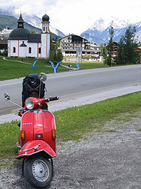 Rote Vespa vor Kirche in Seefeld in Tirol